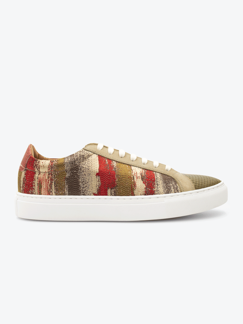 Side view of limited edition Waylen sneaker. Handwoven jacquard cloth with suede and embossed woven leather stitched onto a natural white rubber sole complete with waxed white shoe laces.