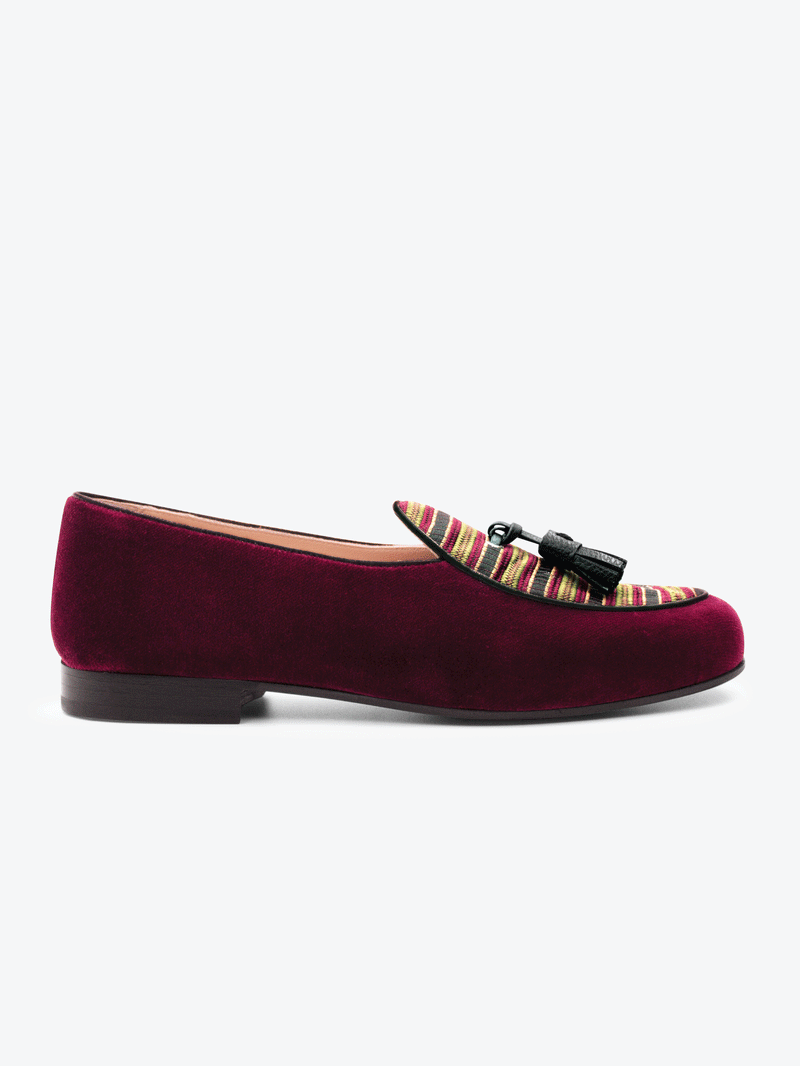 Side view of limited edition Leo 1976 Maroon Belgian slipper. Meticulously handwoven jacquard cloth with full grain leather trims set onto a leather sole with stacked leather heel.