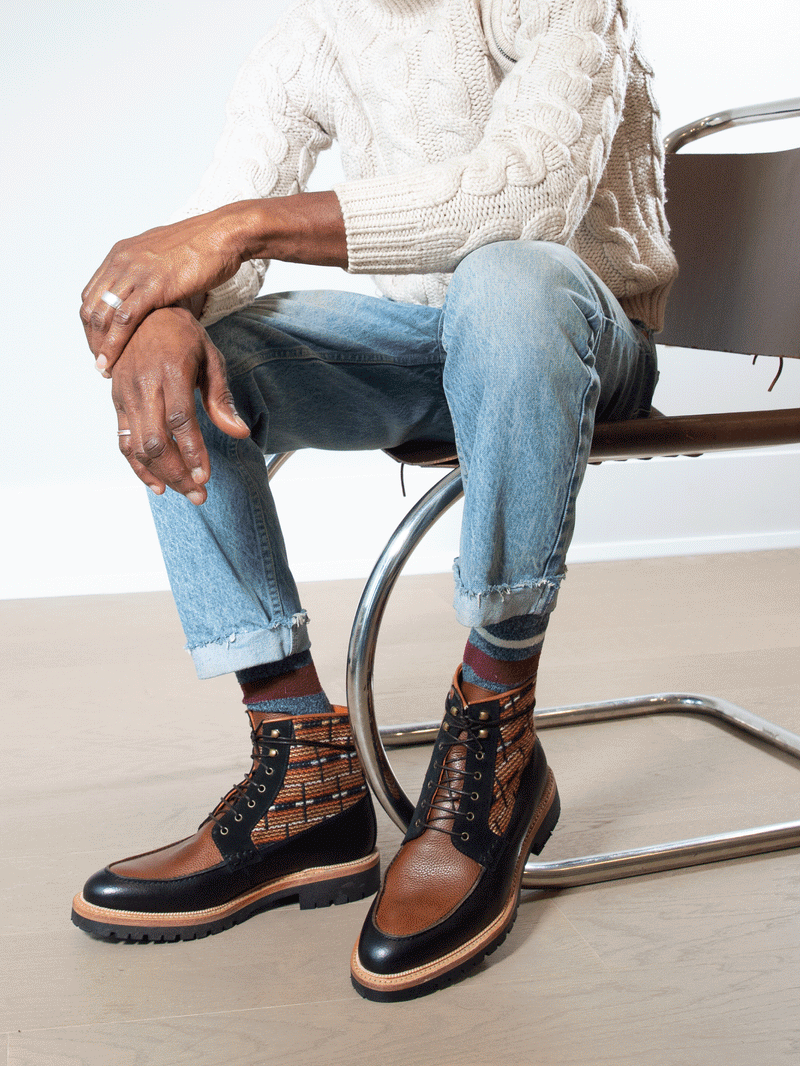 Model wearing limited edition Brooklyn 1997 Symmetry Moc Boot. Handcrafted jacquard cloth with luxurious Italian suede, fullgrain black and cognac leather, lasted on our commando sole using the Goodyear method with storm welt